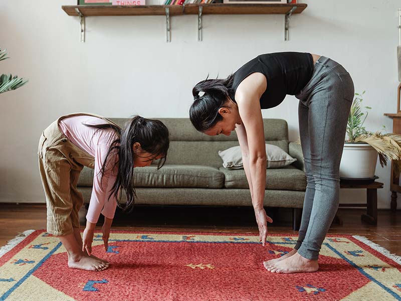 A mother and girl fighting childhood obesity through stretching