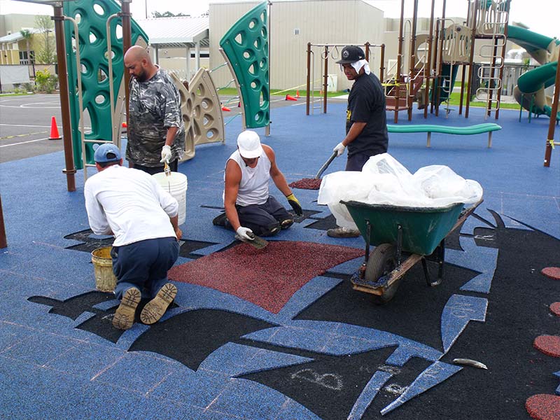 Installing a poured-in-place surfacing pirate ship logo.