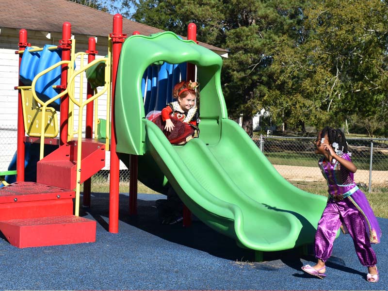 Children enjoying a playground party in their Halloween costumes