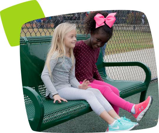 two girls sitting on a metal prakbench